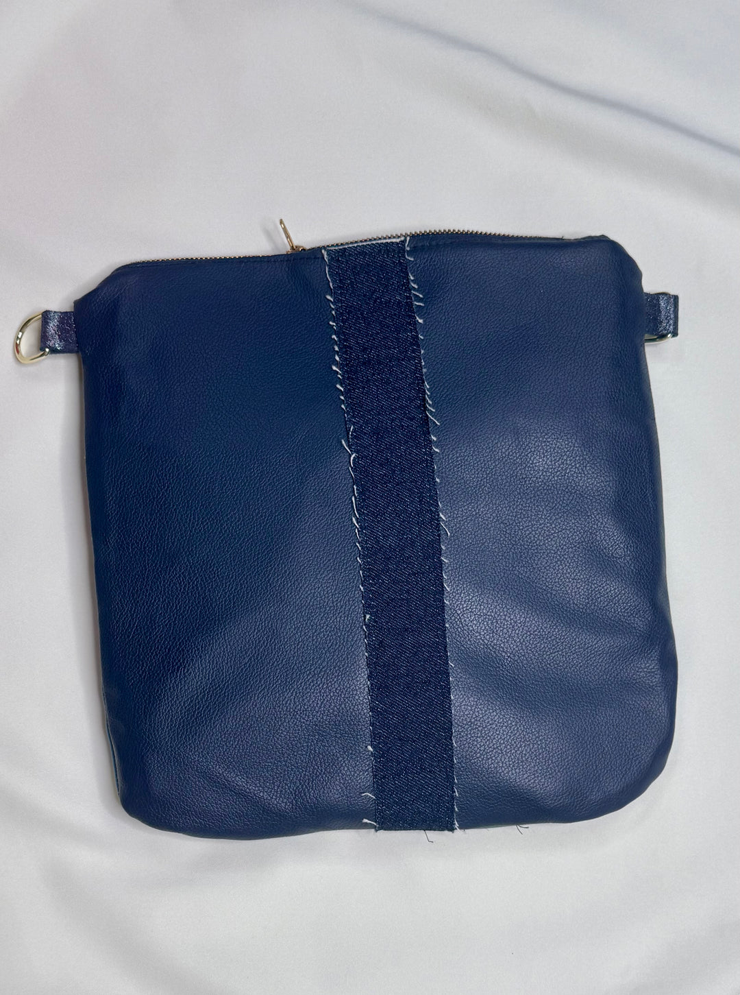 Navy blue pouch with textured strap on a light gray background