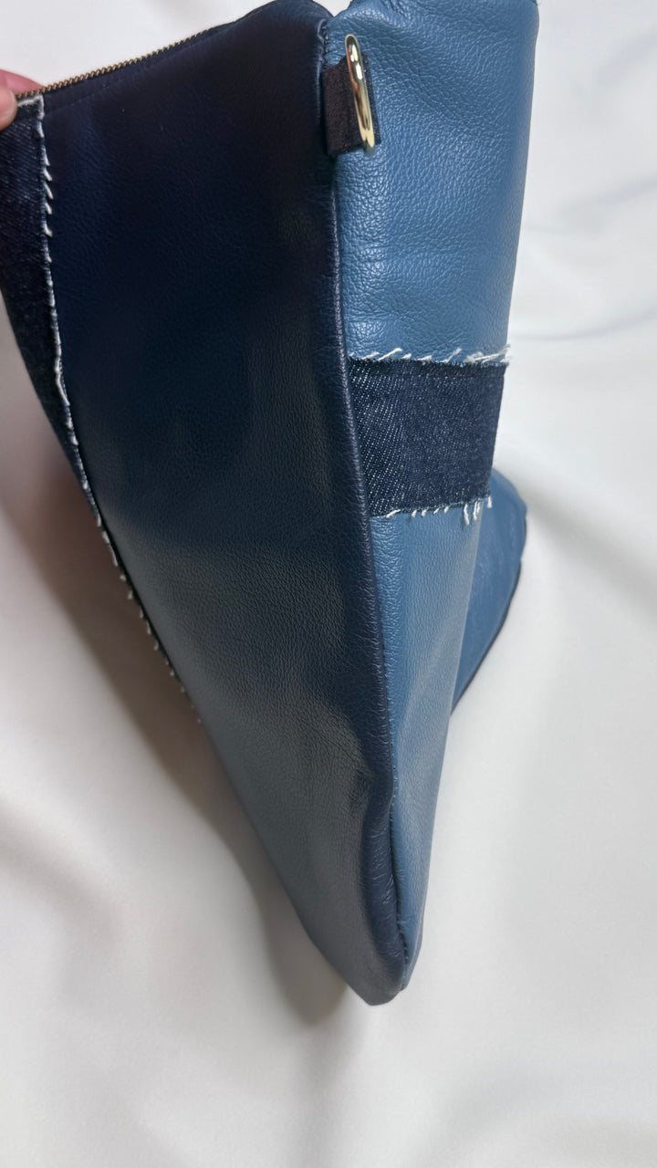 Blue leather clutch bag with a gold clasp on a white background